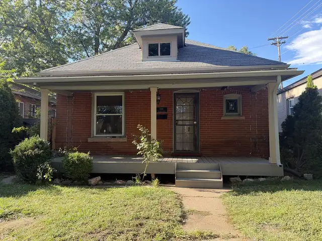 Red brick bungalow with a new gray front porch deck and steps
